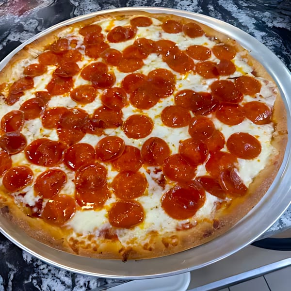 A large, round pepperoni pizza with melted cheese and a golden crust on a metal tray.