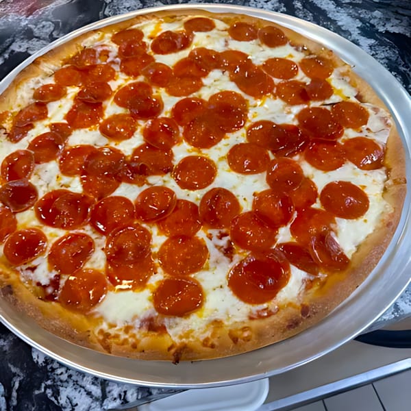 A large, round pepperoni pizza with melted cheese on a metal tray.